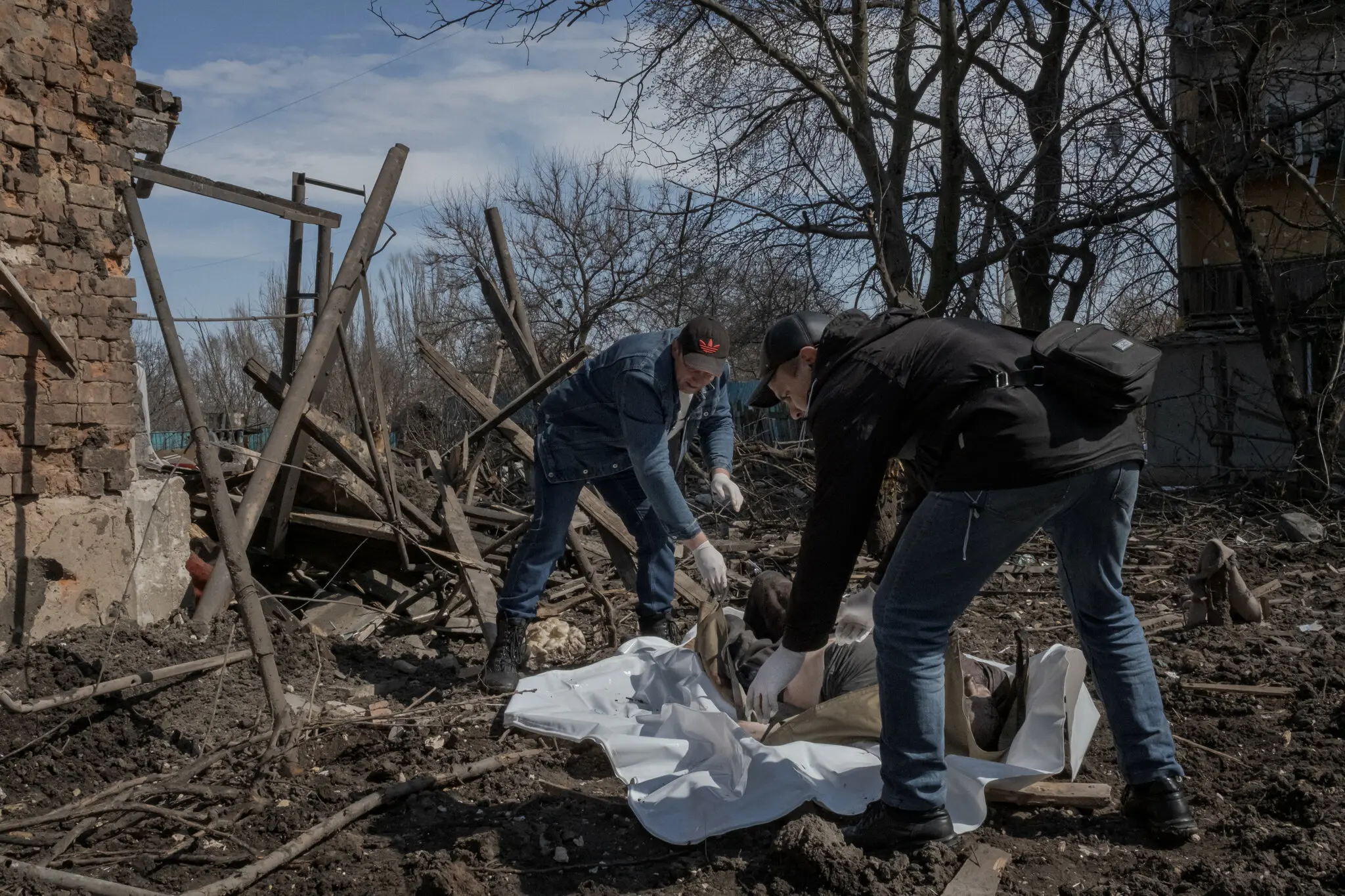 Робітники збирають тіло одного з шести загиблих під час обстрілу подвір'я житлових будинків у Костянтинівці, східна Україна, 2 квітня.